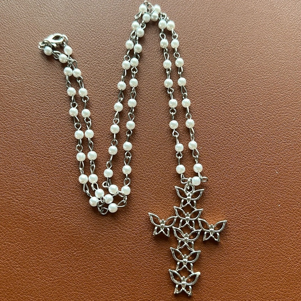 Silver and white cross necklace 24” in length. Cross is made of butterflies.